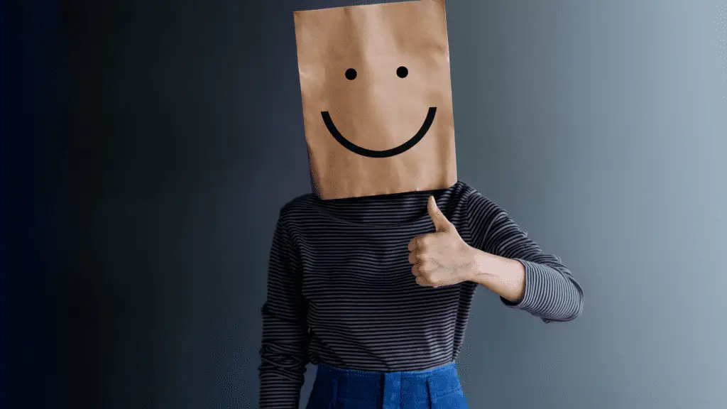 person with paper back over head with smiling face